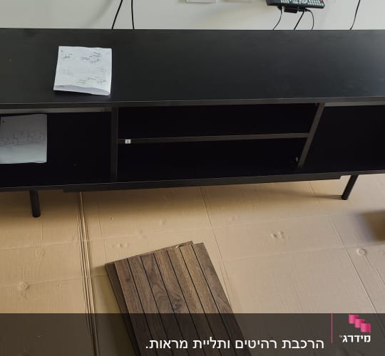 ארון שחור עם דלתות פתוחות והוראות הרכבה